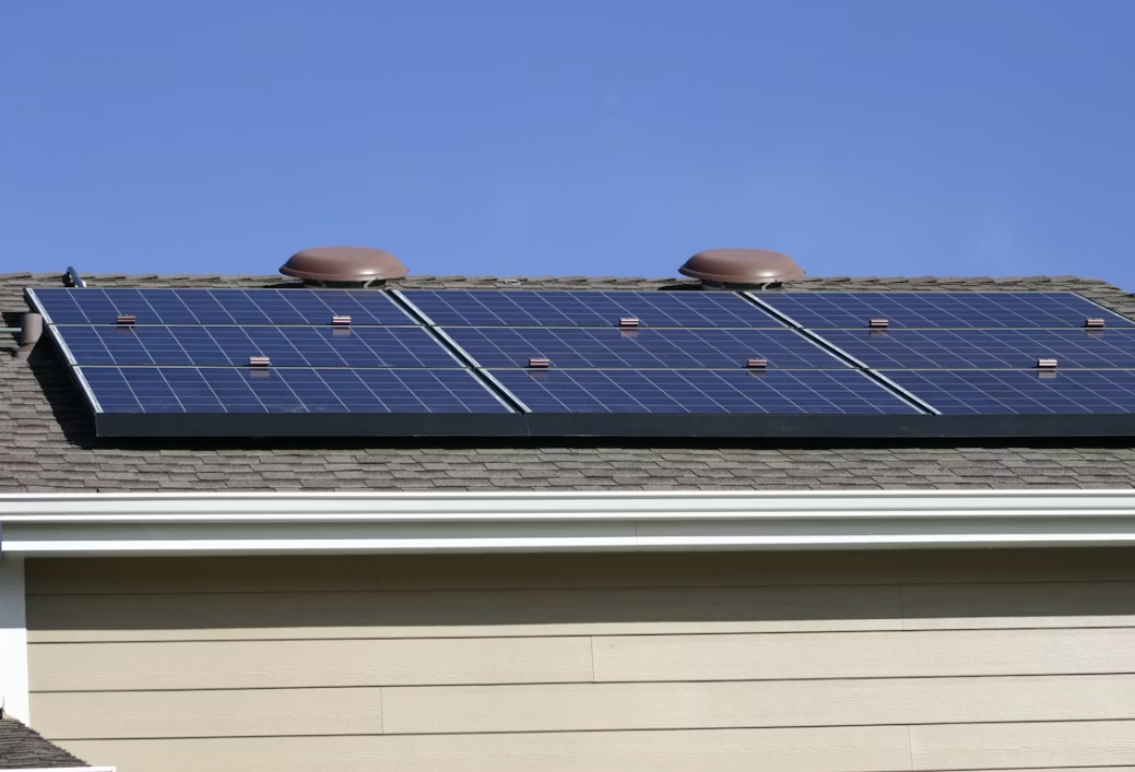 Close view of panels on asphalt shingles with the mounting rails and roof attachments in shot.