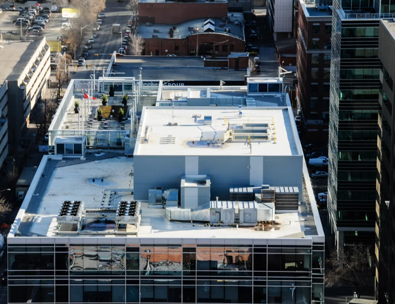 Flat commercial roof with a white single-ply membrane and rooftop mechanical units.