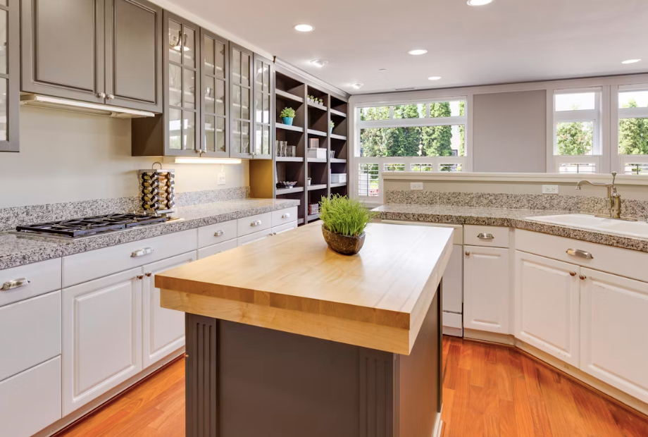 Kitchen with speckled granite perimeter countertops and a butcher block island top.